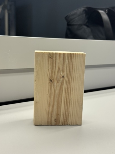 This is an image of a piece of wood. <br><br>
          <b>Material state:</b> refined<br><b>Material plasticity:</b> rigid<br><b>Material use:</b> furniture, decoration, tools<br><b>Feels:</b> smooth sides, rough and sharper ends<br><b>Colour:</b> brown