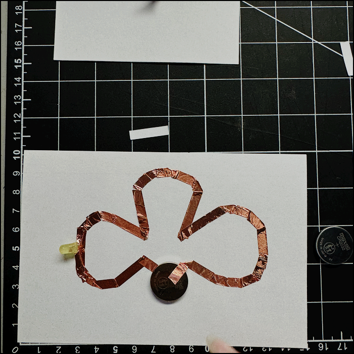 Image of experimentation, modified simple circuit to create a 3 leaf clover shape. Unfortunately this didn't manage to light up as there was no gap for the light created when making the circuit with copper tape