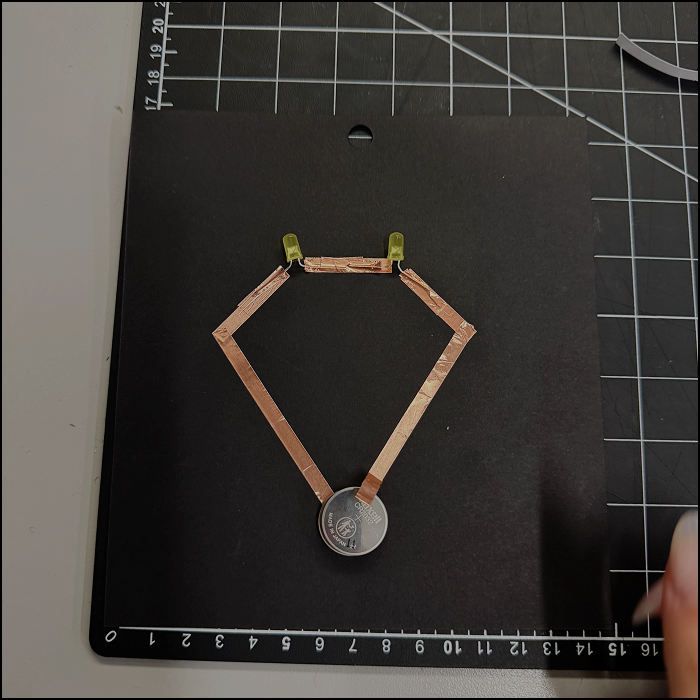 Image of experimentation, modified series circuit with positive side of the copper tape not fully pressed on the battery.