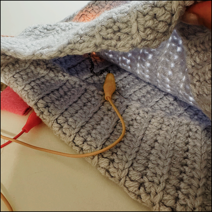 Working simple circuit hidden underneatht the crochet fabric material inside view with circuit visible